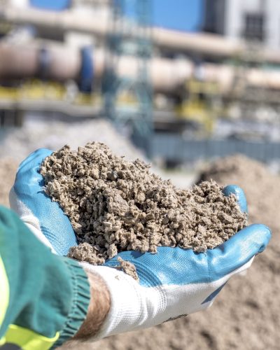 A person holding shredded paper used as an alternative fuel