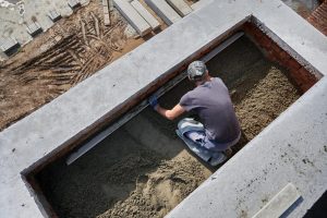 male-worker-screeding-floor-construction-site-min